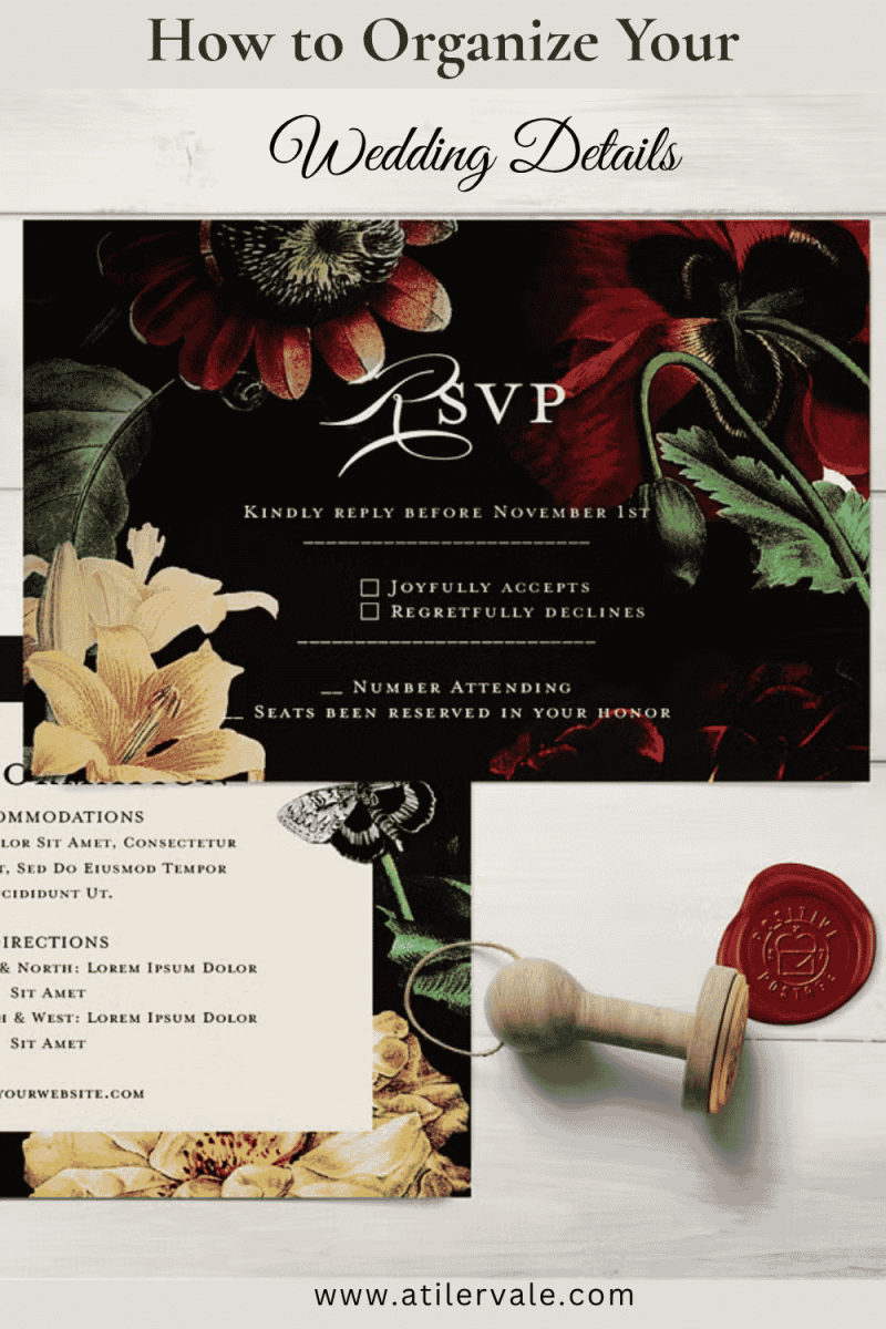 Close-up of a botanical wedding invitation suite with dark floral RSVP card, cream details card, a wax seal, and a wooden stamp on a white wood background.